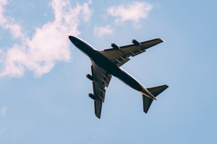 The bottom of a plane flying in the sky