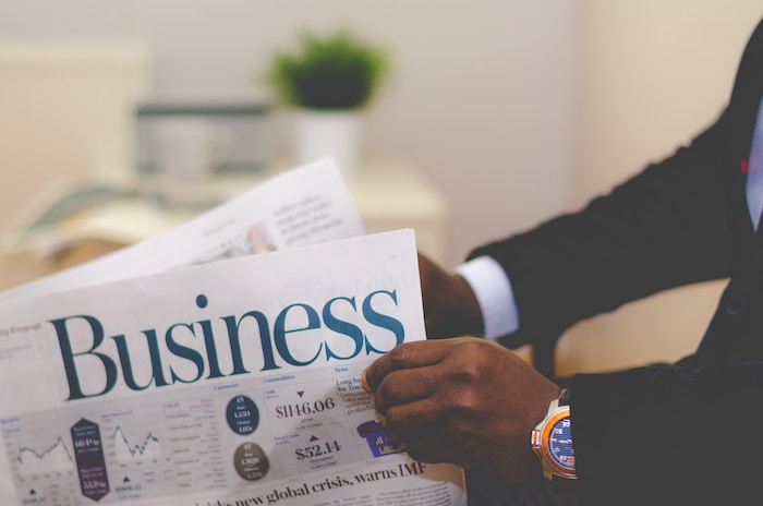A person reading the business section of a newspaper